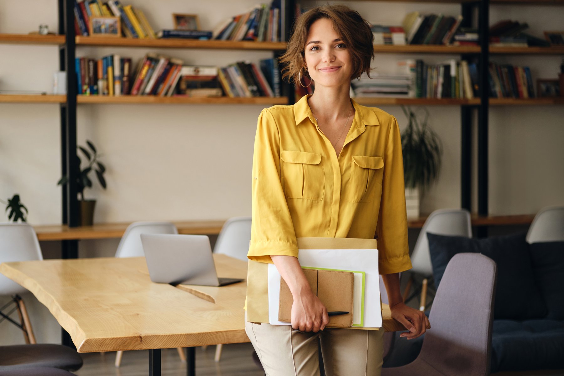 Profesional en un estudio de trabajo luminoso, con cuaderno y documentos